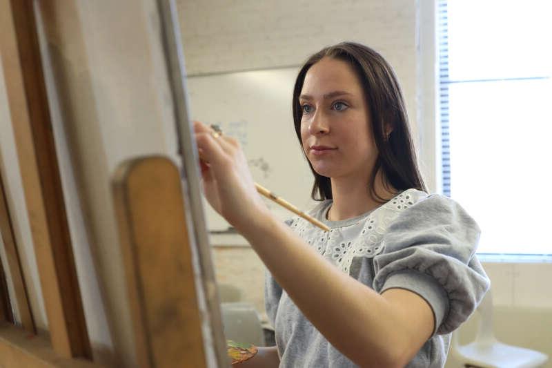 A student paints in art class